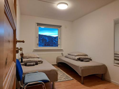 una camera da letto con due letti e una finestra di Michelle's Blue House a Ilulissat