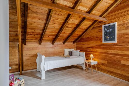 a bedroom with a bed in a wooden room at Barbadine974, Chalet cosy, 6 personnes, Plaine des Cafres in La Plaine des Cafres