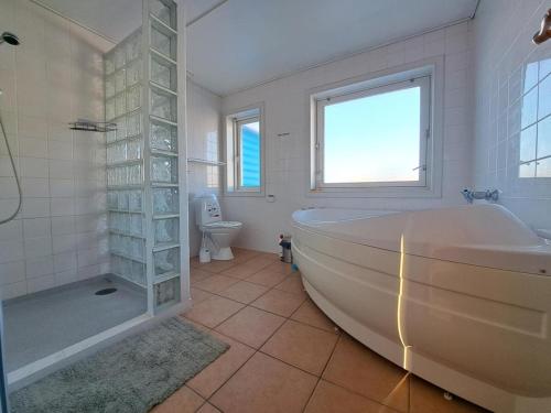 un bagno con vasca, WC e finestra di Michelle's Blue House a Ilulissat