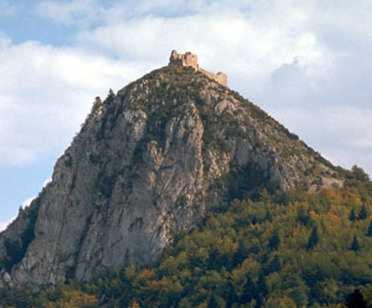 a large rocky mountain with trees on it at Palais Cathare in Bélesta