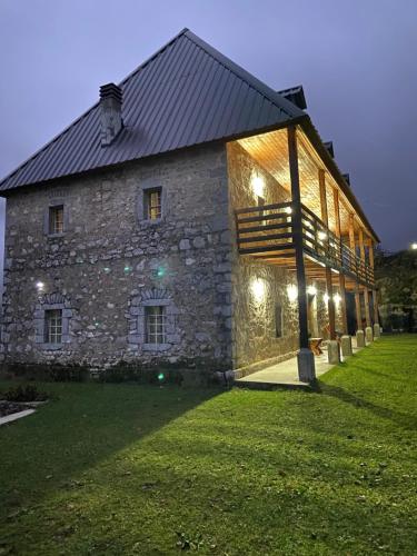 a large stone building with lights on it at Guest House Prebibaj in Curraj i Epërm