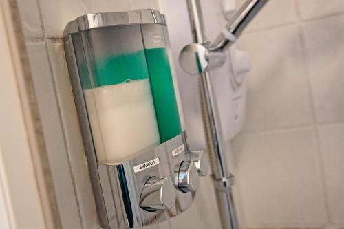 a soap dispenser on a door in a bathroom at Wolfe Tone Apartment in Sligo