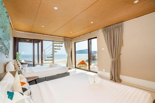 a bedroom with two beds and a view of the ocean at Let go see the Dolphin Samroiyot in Baanphakrimlay 