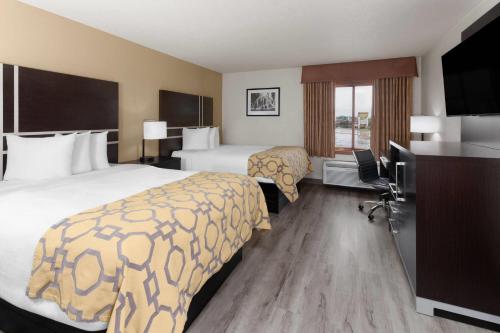 a hotel room with two beds and a television at Baymont by Wyndham Green Bay in Green Bay