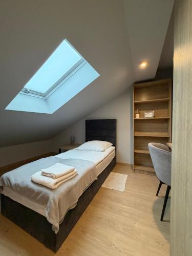 a bedroom with a bed with a skylight at Arcadia Home in Będzin
