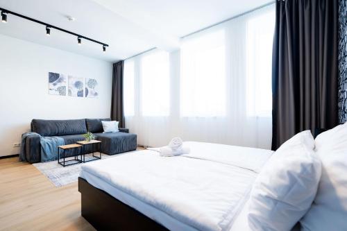 a bedroom with a large bed and a couch at Azure Apartman Miskolc in Miskolc