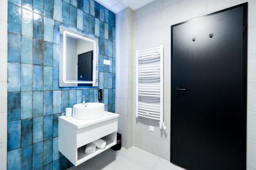 a bathroom with a white sink and a mirror at Azure Apartman Miskolc in Miskolc