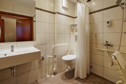 ein Badezimmer mit Toilette, Waschbecken und Dusche in der Unterkunft Hotel Aragon in Ahrensfelde