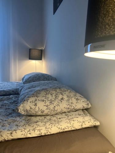 a bedroom with a bed with two pillows and a lamp at Apartament Kołobrzeska 2 in Piła