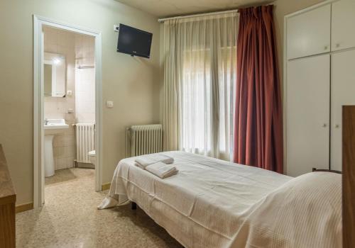 a bedroom with a large bed and a bathroom at Hostal Sant Miquel in Balaguer