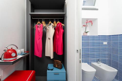 a bathroom with pink clothes hanging on a closet at Domus Pio XI in Sant'Agnello