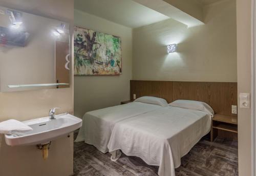 a bedroom with a white bed and a sink at Hostal Sant Miquel in Balaguer