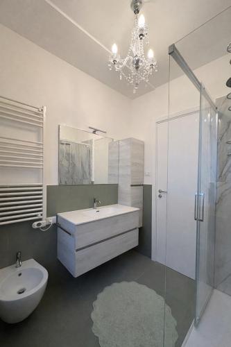 a bathroom with a sink and a toilet and a chandelier at Viola Apartment Monte Felice in Bardolino