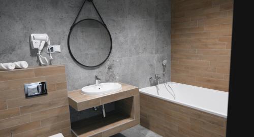 a bathroom with a sink and a tub and a mirror at Soccer Box Pro in Dachnów