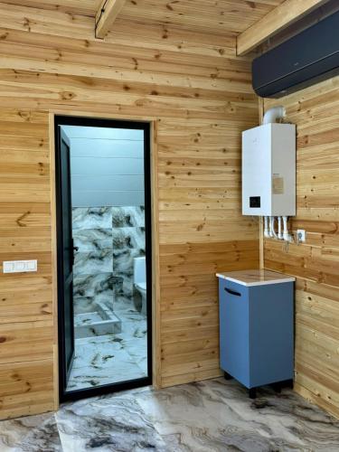 a room with a wooden wall with a door and a mirror at Kedari Borjomi Cottage in Borjomi
