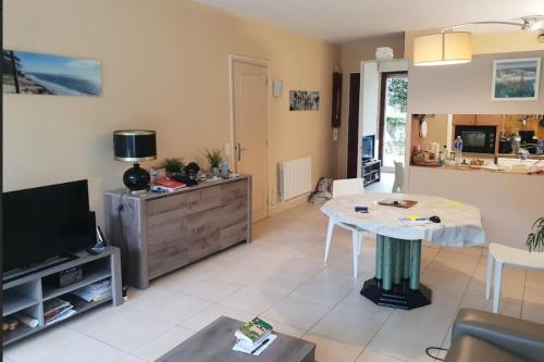 a living room with a television and a table at 100 m from the beach prime location in Arcachon
