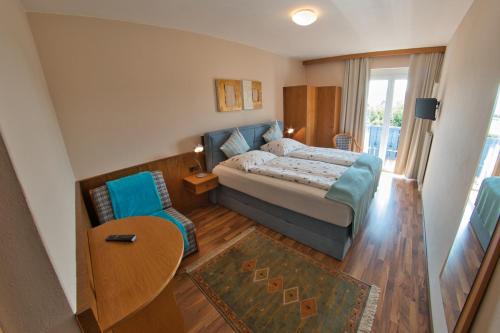 a bedroom with a bed and a table and a chair at Pension Carinthia in Unterburg am Klopeiner See