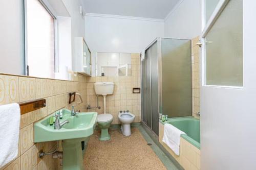 a bathroom with a sink and a toilet and a shower at 2BR Beachfront Escape in Largs North in Semaphore