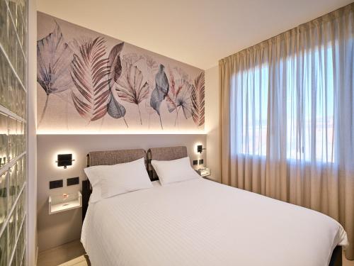 a bedroom with a white bed and a window at Residence Al Centro in Pescantina
