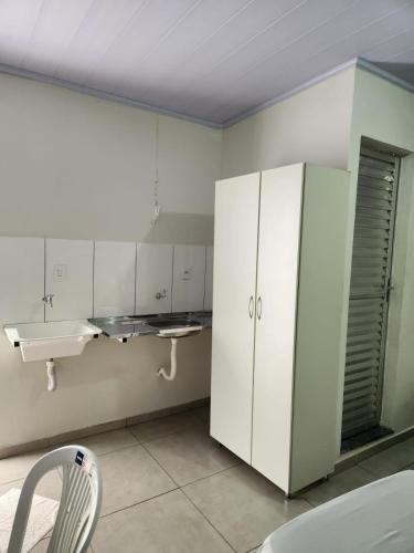 a kitchen with a sink and a white cabinet at Apart hotel in Três Marias