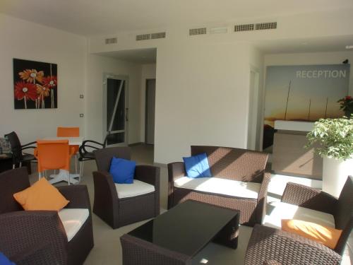 a waiting room with chairs and tables and aception at Residence Rivachiara (check-in at Hotel Riviera in Viale Rovereto, 95) in Riva del Garda