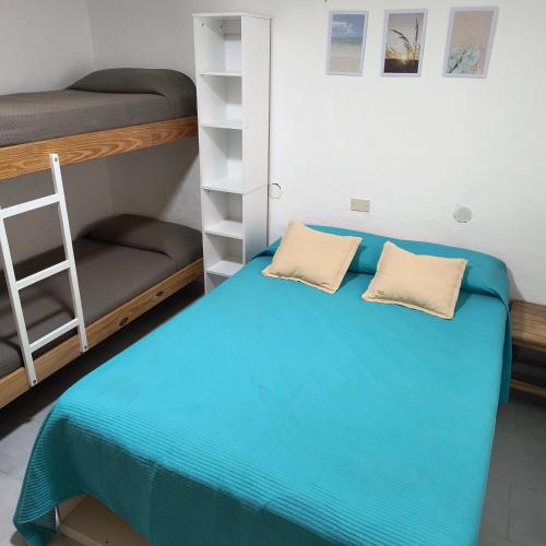 a room with a bed and bunk beds at Casa VLG 5 pax in Las Grutas