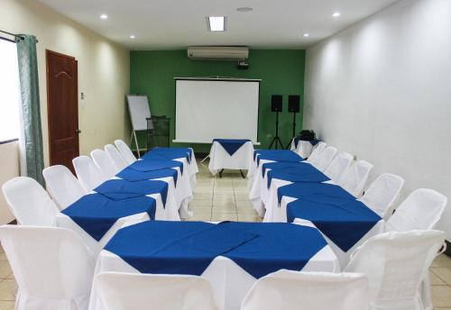 a conference room with blue tables and white chairs at Hotel Palmeras de Elim in Matagalpa