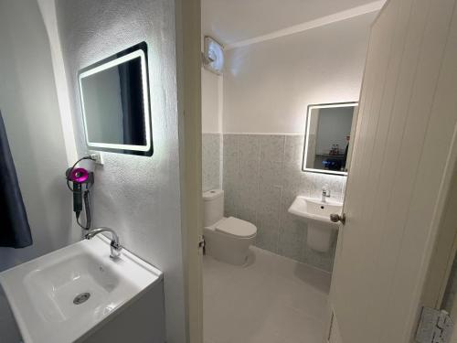 a white bathroom with a sink and a toilet at ดิโอโซน THE Ozone in Ban Bung Sanan
