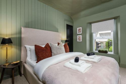 a bedroom with a large white bed with towels on it at The Wallace Suite by The Wallace Monument in Stirling