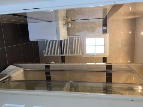 une cuisine avec une table en verre et une fenêtre dans l'établissement koechi, à Magny-le-Hongre