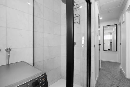 a bathroom with a shower and a sink and a mirror at Sunshine Family Sophistication in Albion