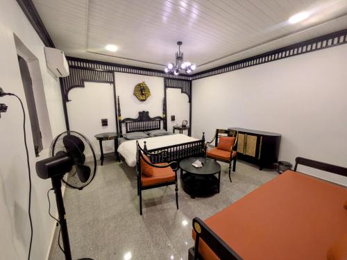 a room with a bedroom with a bed and chairs at Nomada in Mount Ābu