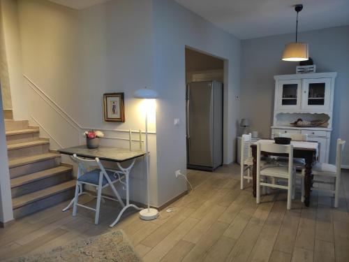 a living room with a table and a kitchen and stairs at Appartamento in Villa in Mondaino