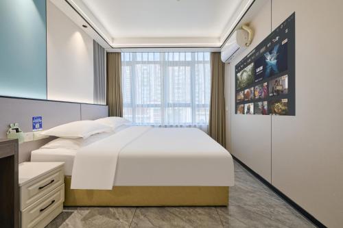 a bedroom with a large white bed and a window at Four Seasons Clouds Xiamen North Railway Station Store in Xiamen
