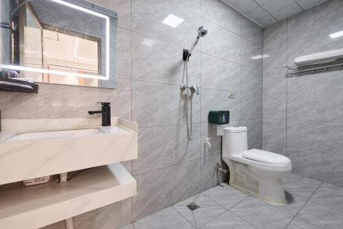 a bathroom with a shower and a toilet and a sink at Four Seasons Clouds Xiamen North Railway Station Store in Xiamen