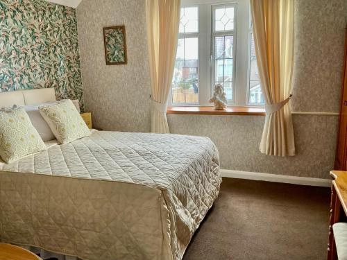 a bedroom with a bed and a window at The Sunningdale in Skegness