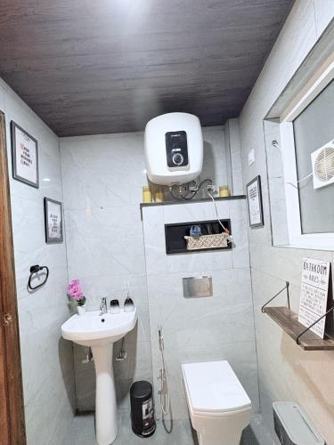 a small bathroom with a sink and a toilet at B&A Stays in Dehradun
