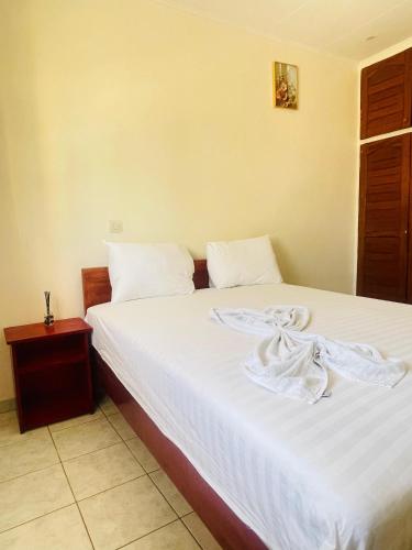 a bedroom with a bed with white sheets at Bulle d'Or Serenity in Libreville