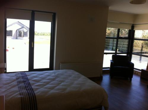 - une chambre avec un lit, une chaise et des fenêtres dans l'établissement Kilmore Quay Castleview 1 - 5 Bedroom House, à Kilmore Quay