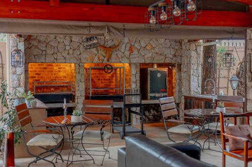 a room with tables and chairs and a stone wall at Afrique Boutique Hotel O.R. Tambo in Boksburg