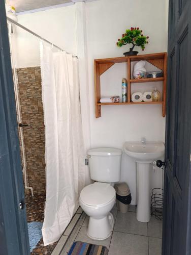 a bathroom with a toilet and a sink at Casa Mariposa Full Accommodation in Sabalito