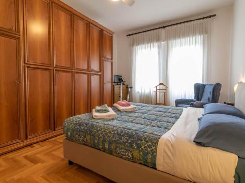 a bedroom with a bed and a large wooden cabinet at Mountain View Apartment Lecco Centro in Lecco