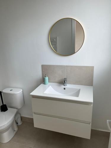 a bathroom with a white sink and a mirror at Maison Solesmes nord in Solesmes