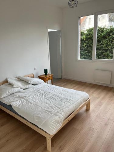 a white bedroom with a large bed in it at Maison Solesmes nord in Solesmes