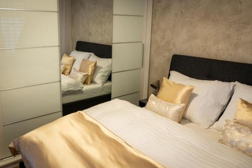 a bedroom with two beds and a mirror at Apartmán u Pivovaru in Rožnov pod Radhoštěm