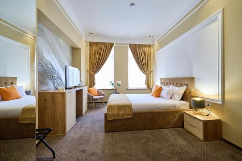 a hotel room with two beds and a television at G Danube Boutique Hotel in Brăila