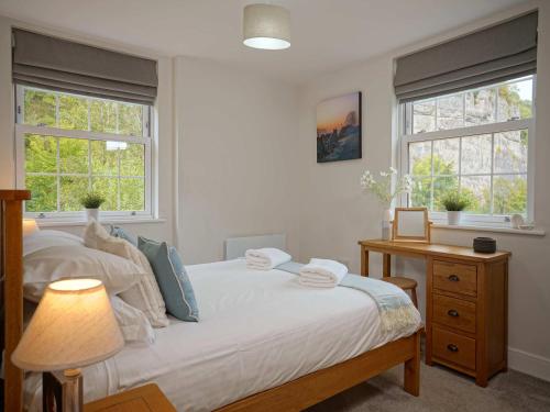 a bedroom with a bed and two windows at Rock Mill 1 Bed Apartment 36 in Stony Middleton