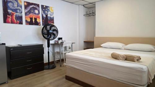 a bedroom with a large bed and a fan at ABC-53 Housing in Medellín