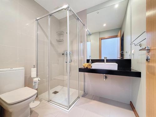 a bathroom with a glass shower and a sink at Sea Garden in Caniço