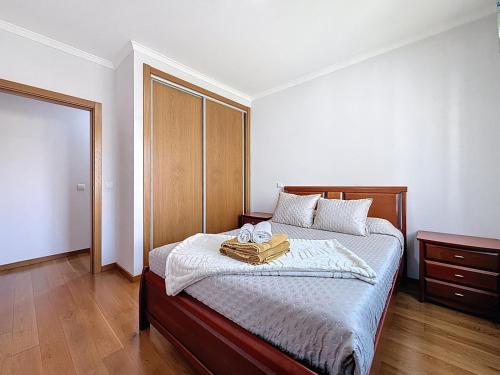 a bedroom with a bed with two towels on it at Sea Garden in Caniço